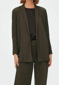 Blazer verde oliva a maniche lunghe con vestibilità rilassata, apertura frontale e senza chiusure, abbinato a una blusa e pantaloni coordinati in verde oliva.