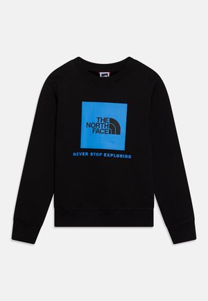 Sweat-shirt noir avec un motif carré bleu portant le texte "THE NORTH FACE" et "NEVER STOP EXPLORING" en dessous. Manches et ourlet côtelés.