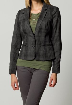 Gray plaid blazer with a tailored fit, single-button closure, and two front pockets, layered over an olive green top.