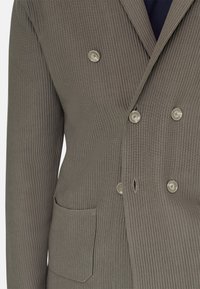 Zweireihiges Sakko aus olivgrünem, geripptem Stoff. Mit silbernen Knöpfen, einer Brusttasche sowie einem glatten, strukturierten Finish.
