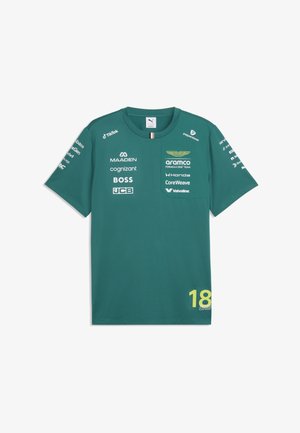 Zielona koszulka zespołu Aston Martin Formuły 1 z wieloma logo sponsorów i żółtą liczbą 18 w dolnym prawym rogu.
