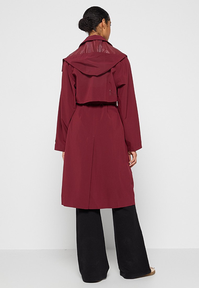 Bordeaux trenchcoat met een gelaagde capuchon, lange mouwen, strikriem en een gladde textuur. Heeft een achterkantopening voor gemakkelijke beweging.