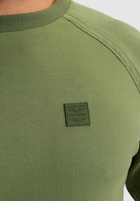 Olijfgroene sweatshirt van zachte stof met geribbelde halslijn en naden; voorzien van een textuurlogo op de linkerkant.