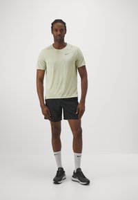 Nike Performance RISE - T-shirt desportiva - olive aura heather/silver
