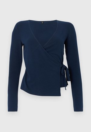 Top închis la culoare cu mânecă lungă, dintr-un material moale, cu decolteu în V, închidere cu legătură laterală și croială lejeră. Textură netedă, cu cusături minime.