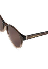 Braune Verlaufssonnenbrille mit runden Rahmen, metallischen Akzenten und goldener Markierung an den Schläfen. Die Gläser sind dunkel und leicht reflektierend.