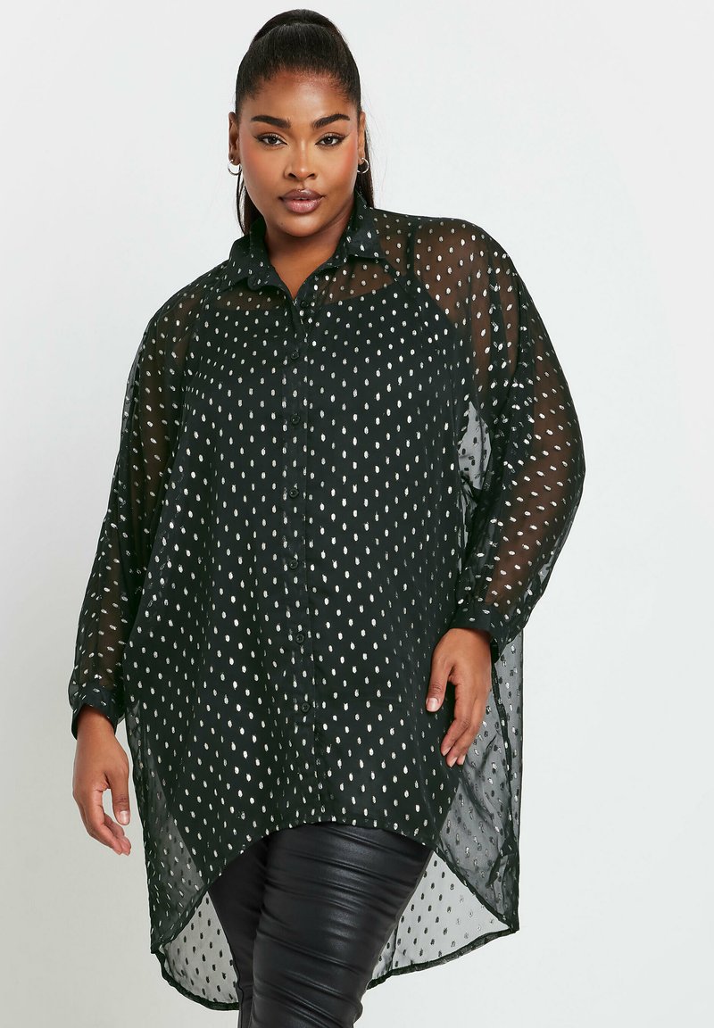 Camicia nera trasparente con bottoni, motivo a pois argentati, maniche lunghe e orlo a barriera. Tessuto morbido e leggero con una vestibilità rilassata.