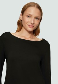 Czarny długi rękaw top wykonany z miękkiego materiału, z szerokim dekoltem i gładką fakturą. Prosty design bez wzorów lub ozdób.