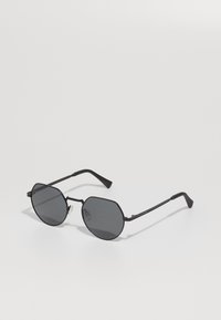 Ochelari de soare octogonali negri, cu lentile întunecate și brațe subțiri, având un design minimalist și o ușoară textură.