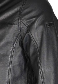 Schwarze Lederjacke mit glatter Textur, detaillierten Nähten, taillierter Passform und einem dezenten Logopatch am Ärmel.