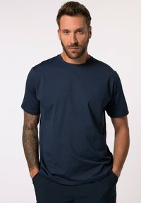 T-shirt a maniche corte blu navy con collo rotondo, caratterizzato da un piccolo ricamo del logo nello stesso colore e un tessuto morbido e texturizzato.
