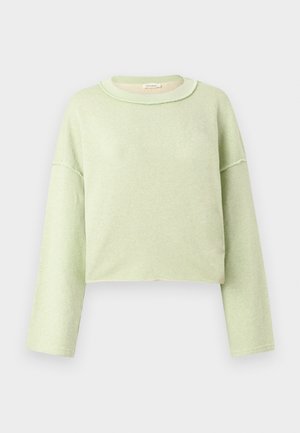 Felpa corta verde chiaro a maniche lunghe con dettagli a bordi grezzi e scollo rotondo su sfondo semplice.