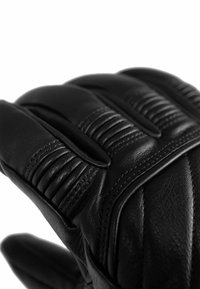 Schwarzer Lederhandschuh mit gerippten Details an den Fingern und weicher Textur, der auffällige genähte Linien und ein eng anliegendes Design bietet.