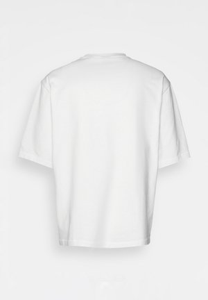 Camiseta blanca de manga corta, corte holgado, cuello redondo, tela de algodón suave, parte posterior sin adornos, dobladillo recto, sin patrones ni acentos.