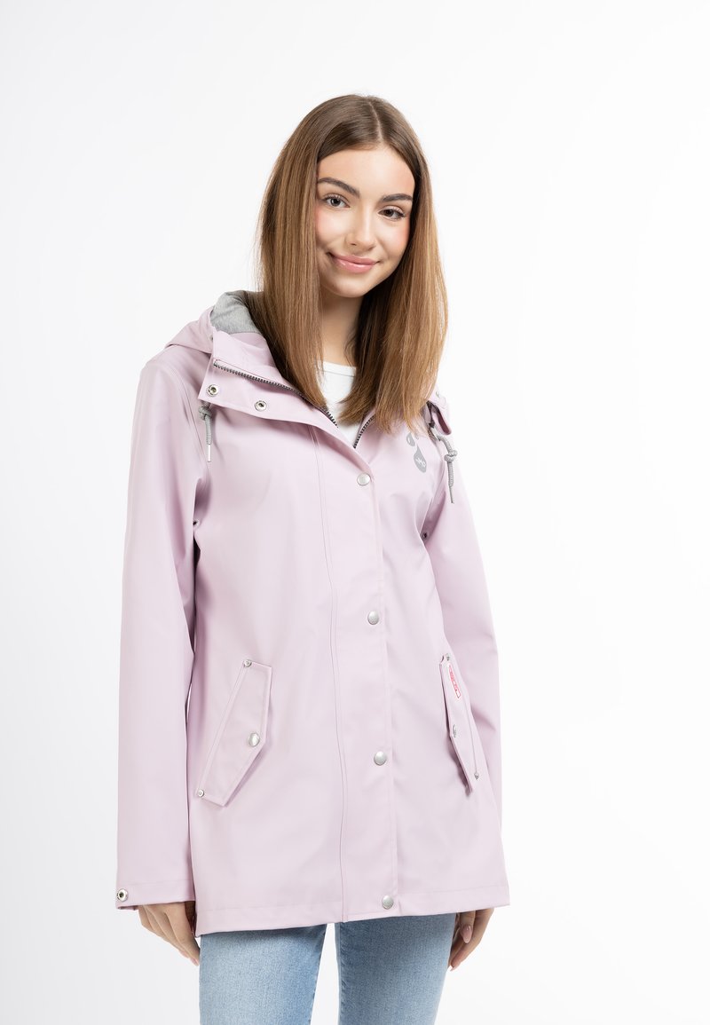 Giacca impermeabile rosa chiaro con cappuccio grigio. Presenta una chiusura frontale con bottoni a pressione, due tasche anteriori e un cordino per una vestibilità regolabile.