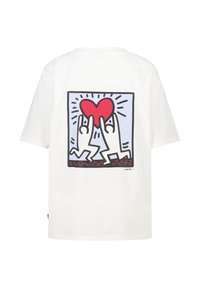 T-shirt en coton blanc avec un motif imprimé représentant deux figures stylisées soulevant un cœur rouge, encadré par un contour noir et un arrière-plan bleu.