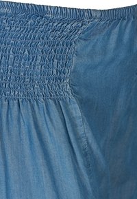 Sininen farkkutakki, jossa on kuminauha vyötäröllä joustoa varten, sileä tekstuuri ja rento istuvuus. Kankaan ulkonäkö on kevyt ja pehmeä.