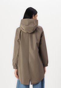 Bruine, knielange regenjas met een capuchon, elastische manchetten en een rechte snit. Gladde textuur en minimalistisch ontwerp, geen zichtbare sluitingen.