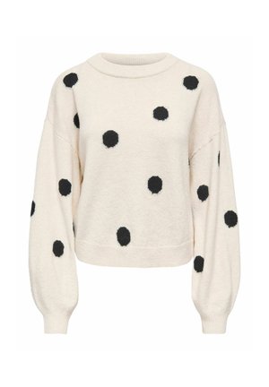 Langærmet cremefarvet sweater med sorte polkaprikker, rund halsudskæring og ribkanter ved ærmer og kant, vist på hvid baggrund.