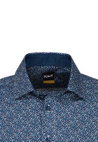 Camicia a bottoni blu navy con un motivo floreale bianco e azzurro; presenta un colletto strutturato e bottoni blu. Il materiale ha una consistenza liscia.