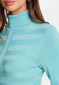 Pull en col roulé bleu clair avec des rayures horizontales et une texture côtelée. La vue rapprochée met en avant le détail du tissu et la coupe ajustée.