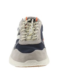 Sneaker grigio e blu navy realizzato in materiali mesh e suede, dotato di lacci a righe, suola testurizzata e un accento arancione vicino alla linguetta.