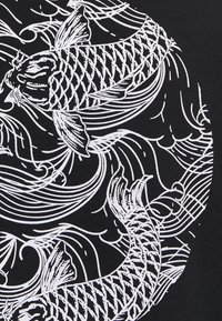 Tessuto nero con un'illustrazione bianca di pesci koi, con squame dettagliate e linee fluide che rappresentano il movimento dell'acqua.