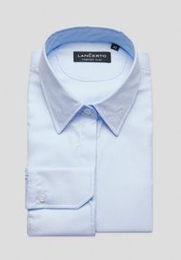 Jasnoniebieska koszula z długim rękawem i kołnierzykiem zapinanym na guziki, o gładkiej fakturze i starannie złożonych mankietach. Etykieta widoczna wewnątrz kołnierza.