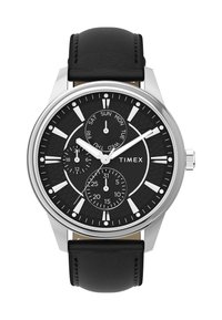 Timex-klocka med en svart texturerad urtavla, silverfärgad rostfri stålkapsel, vita timmarkörer och svart läderarmband. Har datum- och veckodagsvisningar.