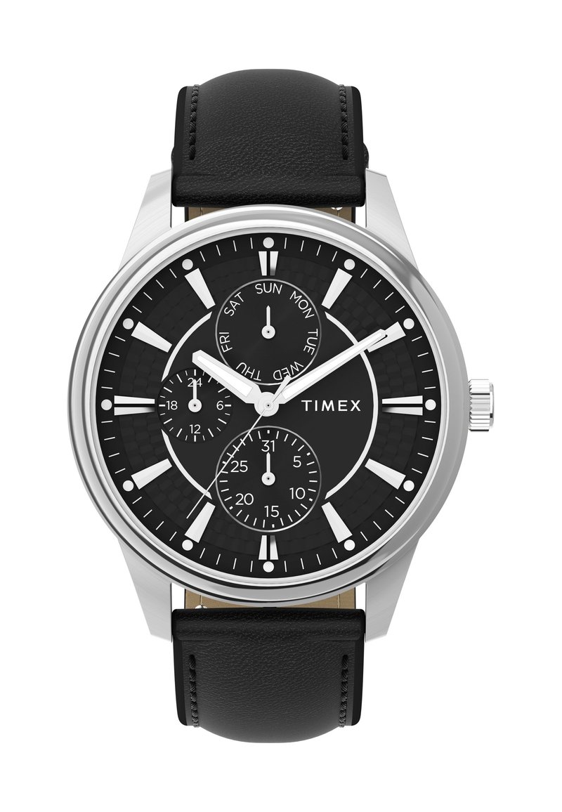 Timex-klocka med en svart texturerad urtavla, silverfärgad rostfri stålkapsel, vita timmarkörer och svart läderarmband. Har datum- och veckodagsvisningar.