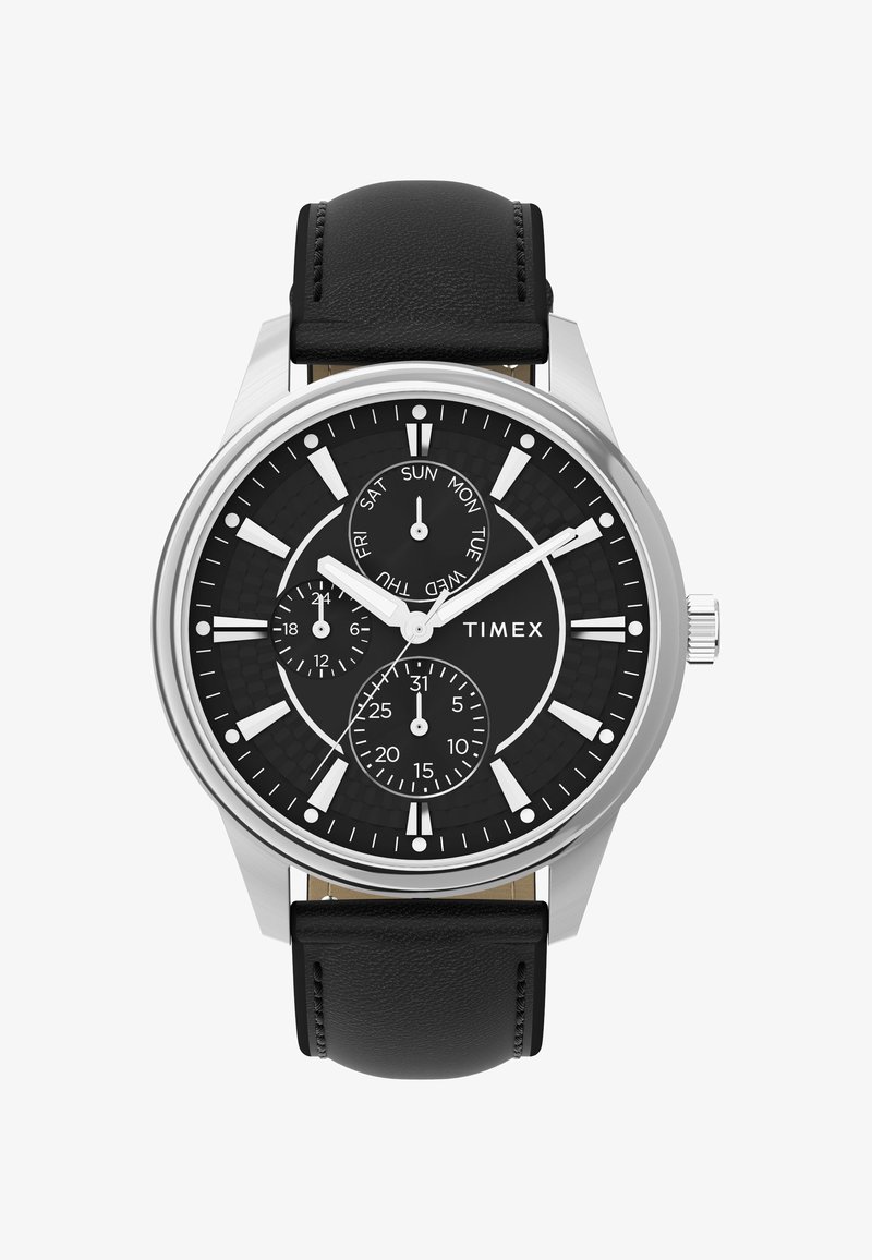 Timex-klocka med en svart texturerad urtavla, silverfärgad rostfri stålkapsel, vita timmarkörer och svart läderarmband. Har datum- och veckodagsvisningar.