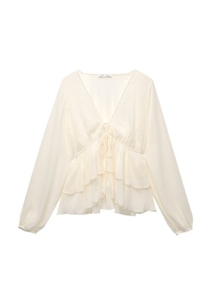 Blouse de couleur crème avec un col en V, des manches longues en ballon et des volants superposés à l'ourlet, avec un d�étail de nœud au centre du dos.