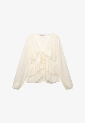 Cream-colored blouse featuring a V-neck, long balloon sleeves, and layered ruffles at the hem, with a tie detail in the center back.
