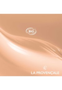 Produit cosmétique avec une texture lisse et crémeuse dans une couleur pêche chaude. Présente un logo de certification BIO circulaire et le nom de la marque, La Provençale.