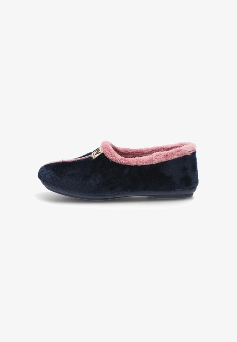 Zapatilla de felpa azul marino con suave forro y ribete rosa. Presenta una suela plana y un pequeño acento de logo dorado cerca de la abertura.