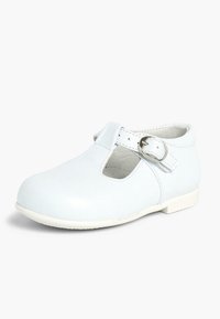 Witte leren Mary Jane-schoen met een ronde neus, een zijgesp en een uitgesneden ontwerp. Heeft een lage, witte rubberen zool.