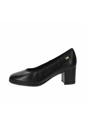 Scarpa con tacco in pelle nera, con punta arrotondata, interno imbottito e tacco a blocco. Presenta un piccolo accento decorativo in metallo sul lato.