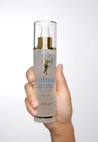 Bottiglia spray trasparente con tappo a pompa dorato. Presenta testo blu "rahua" e un logo su uno sfondo translucido. Dimensioni 5,4 fl oz/157 ml.