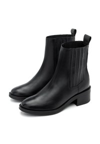 Une paire de bottines noires en cuir avec de petits talons carrés et des panneaux élastiques sur les côtés pour un enfilage facile.