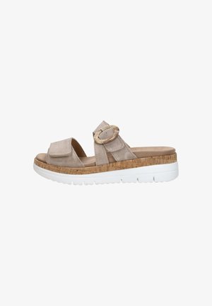 Beige suede slide sandals with two straps, a large round buckle, textured cork midsole, and a white rubber sole.