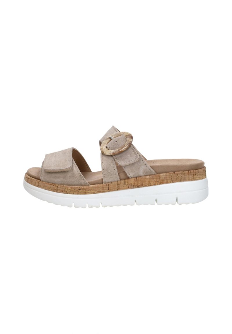 Beige suede slide sandals with two straps, a large round buckle, textured cork midsole, and a white rubber sole.