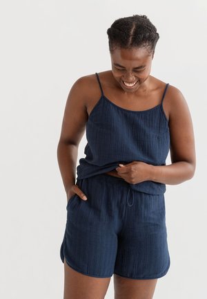 Marineblauwe, mouwloze top met dunne bandjes en bijpassende shorts. Gemaakt van textuurstof, met een elastische tailleband en zijzakken.