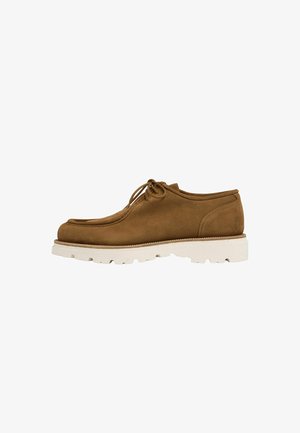 Brauner Veloursleder-Schnürschuh mit dicker weißer profillierter Sohle, Moc-Toe-Design und niedrigem Knöchelschnitt, seitlich auf weißem Hintergrund dargestellt.