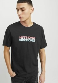 T-shirt in cotone nero caratterizzato da un design grafico multi-colore "JACK&JONES" sulla parte anteriore, maniche corte e scollo rotondo.