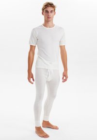 Hvid tætsiddende t-shirt og matchende lange underbukser lavet af let, blødt stof med ribbede manchetter og en glat tekstur.