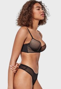 Black lingerie set featuring a mesh bra with a diamond pattern and adjustable straps, paired with matching brief-style bottoms.