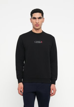 Sweatshirt negru din bumbac cu guler rotund, având un grafic al logo-ului "TOMMY HILFIGER" în roșu și alb pe piept. Textură moale și manșete cu dungi.