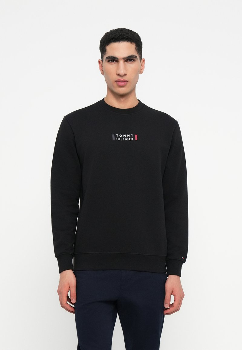 Μαύρο φούτερ από βαμβάκι με στρογγυλή λαιμόκοψη, με γραφικό λογότυπο "TOMMY HILFIGER" σε κόκκινο και λευκό χρώμα στο στήθος. Μαλακή υφή και ribbed μανσέτες.