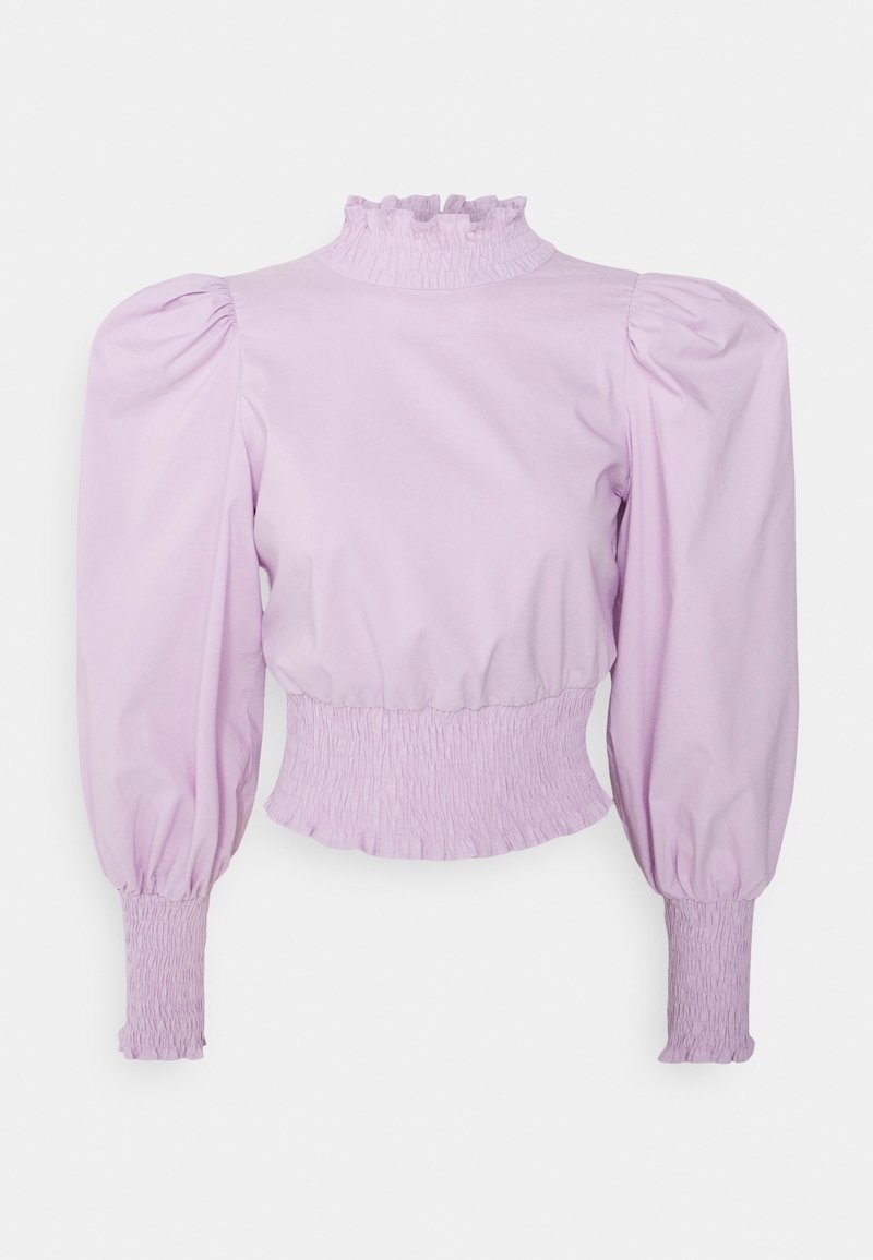 Blouse lavande à manches longues avec épaules bouffantes, col montant froncé, taille et poignets, présentée sur un fond uni.