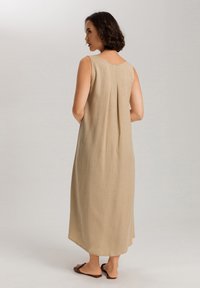 Beige, bezramínková maxi šaty s uvolněným střihem. Má kulatý výstřih a skládací detail na zádech. Vyrobeno z lehké, texturované látky.